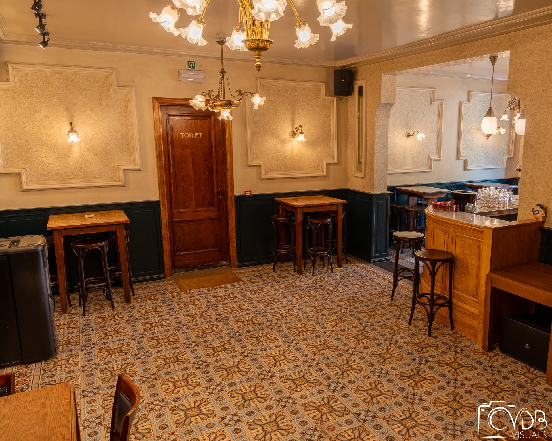 Authentieke feestzaal van Café Chaos in Turnhout met tafels, toog en historische details