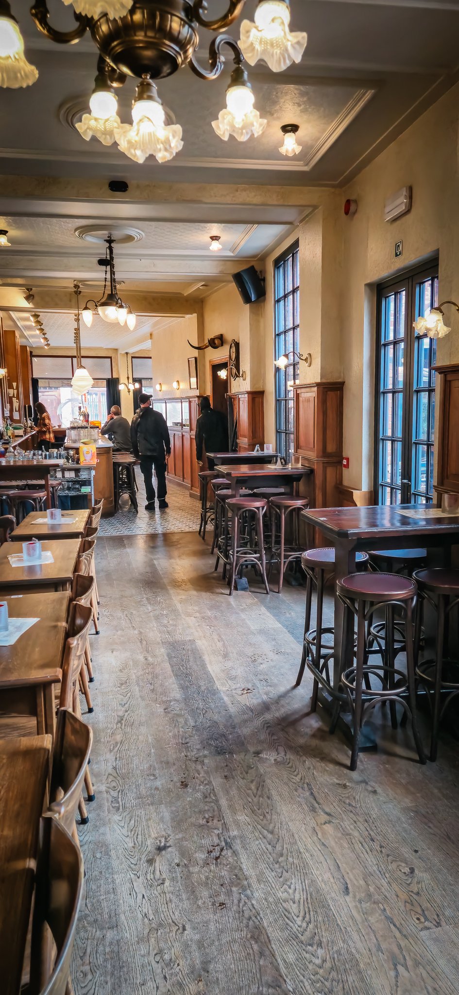 Huidig interieur van Café Chaos met houten tafels en historische verlichting