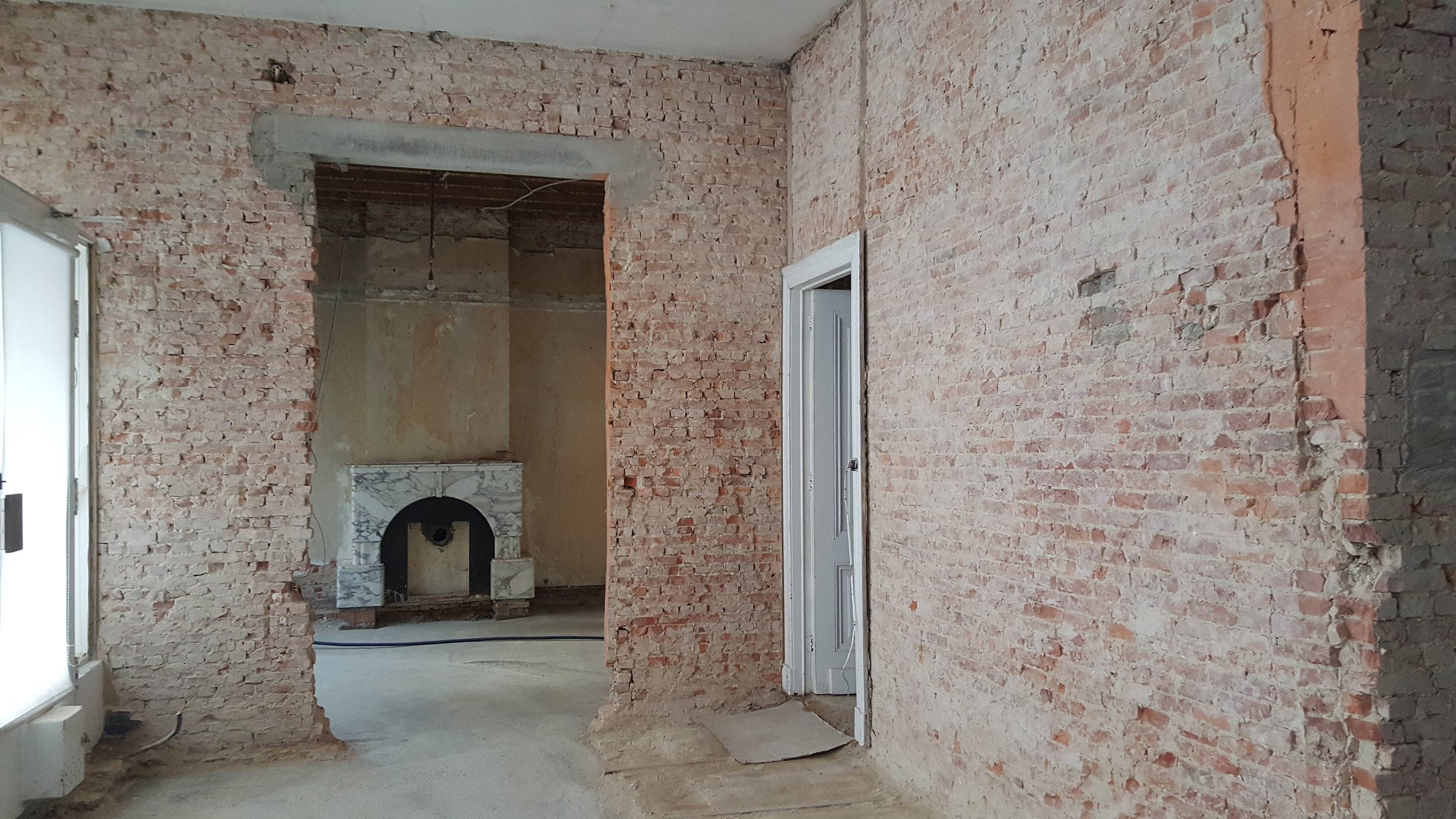 Café Chaos tijdens de renovatie met blootgelegde bakstenen muren